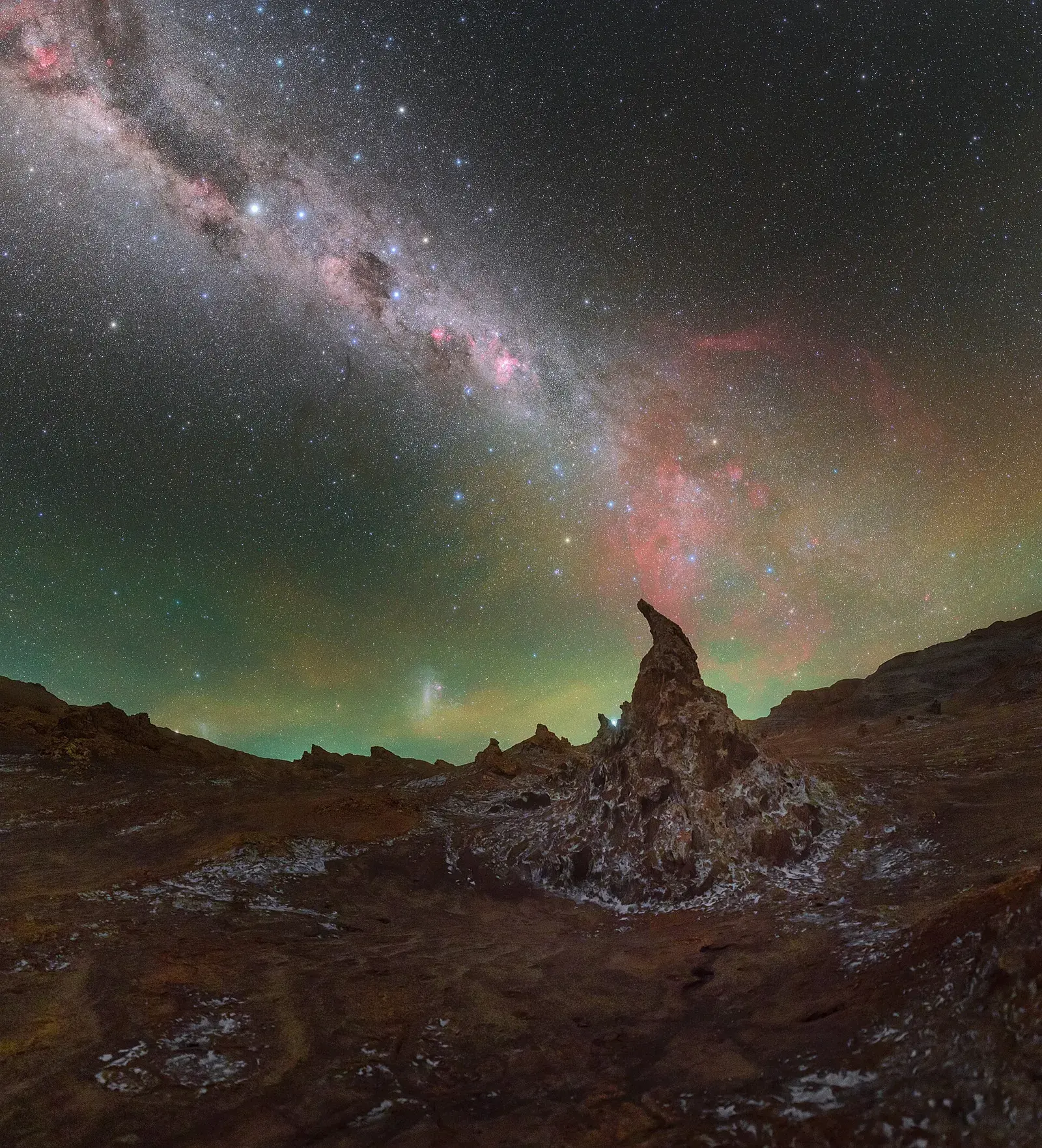 The Milky Way arching over twisted rock formations in the Atacama Desert